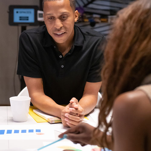 man and woman sitting at a table having a meeting